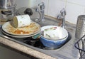 Dirty dishes in a sink for washing up.