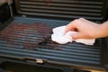 Dirty electric grill. Female hand wiping grill