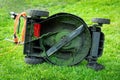 Dirty electric lawn mower in green grass