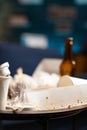 Dirty empty living room with food trash, bottle of beer and napkins on blue sofa Royalty Free Stock Photo