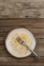 A dirty empty plate on wooden table after dinner Royalty Free Stock Photo