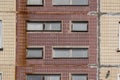 Dirty facade of a shabby prefabricated concrete house, lined with glossy ceramic tiles with decorative windows, close-up, textured