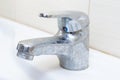 Dirty faucet with limescale, calcified water tap with lime scale on washbowl in bathroom Royalty Free Stock Photo