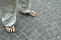 Dirty feet of a man wearing flip flops on the old stone floor. Royalty Free Stock Photo