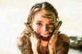 Dirty female model. Woman in clay mask laughs. Crazy girl in medical mud. Spa Outdoor. Happy dirty woman in Dead sea