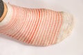 Dirty female striped socks on a white background top view
