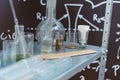 dirty flasks. Chemical laboratory and a shelf with bottles on the background of physical formulas. Royalty Free Stock Photo