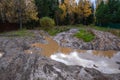 Dirty forest road with a large muddy puddle and reflected clouds Royalty Free Stock Photo