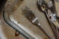 Dirty fork knife and spoon covered with icing under water inside kitchen sink Royalty Free Stock Photo