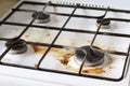Dirty gas stove with food debris and grease stains. A dirty gas stove with grease stains, old grease stains, frying