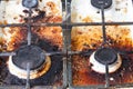 Dirty gas stove surface. Two gas burners and cast iron grate of a gas oven surrounded by old leftovers of food and drinks. Top Royalty Free Stock Photo