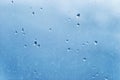 Dirty glass on a blue background with transparent raindrops