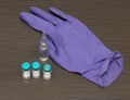 Dirty glove with vaccine vials on table