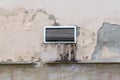 Dirty greasy exterior ventilation grill with dirt streaks on a peeled old cement restaurant wall Royalty Free Stock Photo