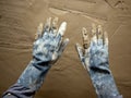 Dirty grunge gloves hands on cement mortar wall