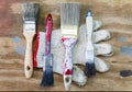 Dirty grunge paintbrushes and glove on dirty rusty wooden background Royalty Free Stock Photo