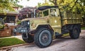 Dirty grungy large Heavy duty former US Army Truck with sign Hip and Knee Doctor on side and machine gun Royalty Free Stock Photo