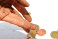 A dirty hand carrying coins on the white floor background. Royalty Free Stock Photo