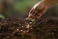 Dirty hand of farmer sowing seed on prepared soil