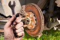 Dirty hand holding wrench. Mechanic is repairing the brakes on a passenger car. Royalty Free Stock Photo