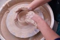 Dirty hands of a ceramist make a cup of clay on a potter& x27;s wheel. Royalty Free Stock Photo