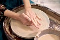 Dirty hands of a ceramist make a cup of clay on a potter& x27;s wheel. Royalty Free Stock Photo