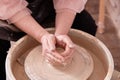 Dirty hands of a ceramist make a cup of clay on a potter& x27;s wheel. Royalty Free Stock Photo