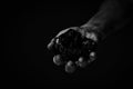 Dirty hands miner holding coal in black and white photo.Heavy coal mining