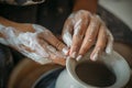 Dirty hands in white clay, pottery wheel with bowl or jar. Potter at work, woman`s hands Royalty Free Stock Photo