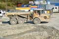 Dirty heavy Volvo dumper loaded by rock moving in work site. Royalty Free Stock Photo