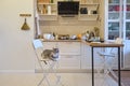 Dirty home kitchen with unwashed washing dishes and junk among the things. The cat is sitting on a high bar stool Royalty Free Stock Photo