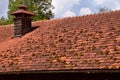 dirty house roof with broken gutter and fancy and skilful fireplace Royalty Free Stock Photo