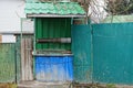 Old iron well of green color on the street near the fence