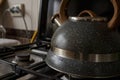 Dirty kettle stands on a gas stove in the kitchen