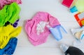 Dirty kids clothing is scattered on a white wooden table.Concept of searching for information on washing spots, the best