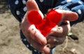 Dirty kids hands holding handful of soil , tinted red heart, abandoned children concept, concept against child labor exploitation