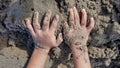 Dirty kids hands playing sands at the beach. Kids hand on sandy beach. Concept of children playing outdoor