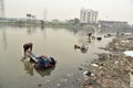 Dirty Laundry: Washerman wash clothes in polluted water Royalty Free Stock Photo