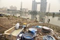 Dirty Laundry: Washerman wash clothes in polluted water Royalty Free Stock Photo