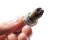 Dirty Lean Spark Plug. Auto mechanic holds an old spark plug on white background Royalty Free Stock Photo