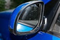 Dirty left side view mirror close - up of a blue car Royalty Free Stock Photo