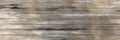 Dirty light brown grey wooden surface with scratched messy parts in horizontal woody lines.