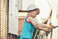 Dirty little boy washes toy bulldozer under running water Royalty Free Stock Photo