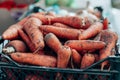 Dirty mature little carrot vegetables in plastic boxes on a farmers market. Fresh organic healthy vegetables at grocery