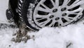 Dirty messy snow near car wheel. Mud, salt and chemicals on winter road. Ecology problem in city. Protection and wash auto concept Royalty Free Stock Photo