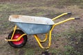 Dirty metal garden wheelbarrow on bare ground Royalty Free Stock Photo