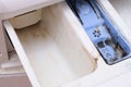 Dirty moldy washing machine detergent and fabric conditioner dispenser drawer compartment close up. Mold, rust and limescale in