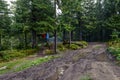 Dirty mountain road with puddles after a thunderstorm go to the tent, next to which dry wet jackets Royalty Free Stock Photo