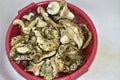 Dirty mushrooms are piled in a basin with water for cleaning