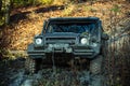 Dirty offroad car stuck in rut with nature on background.